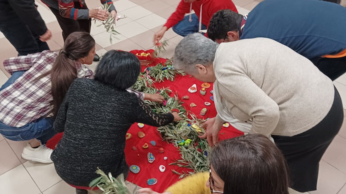 Persone attorno a foglie di ulivo pasquale