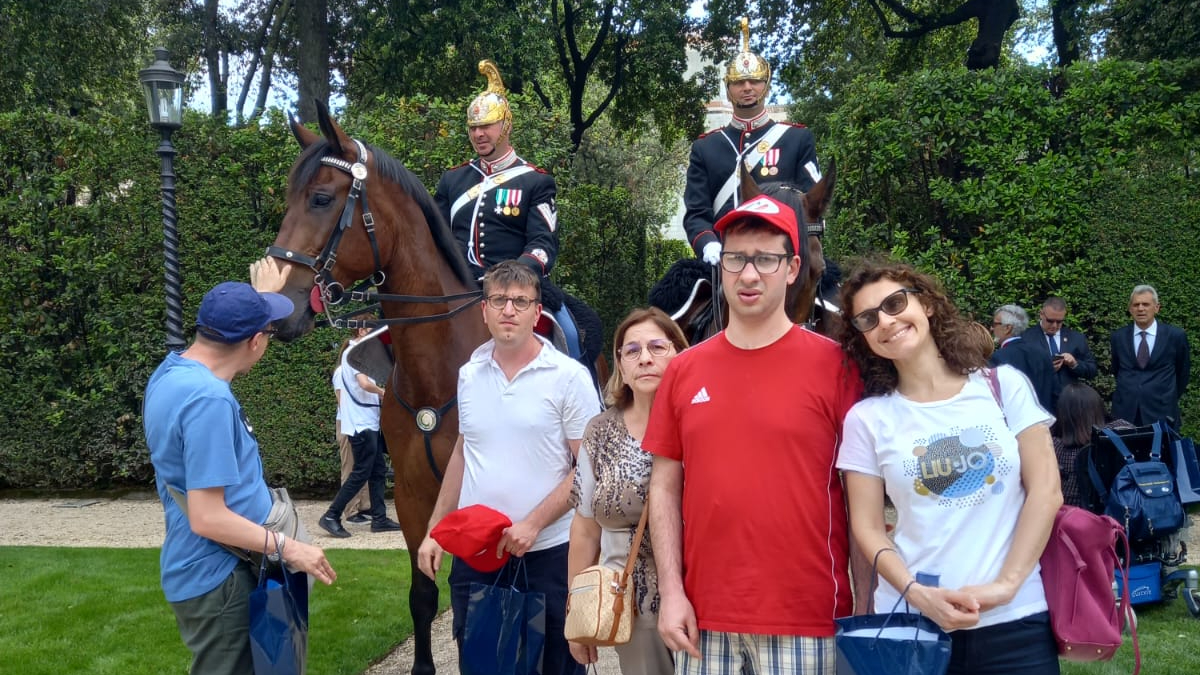 Gruppo di persone ai Giardini del Quirinale con un corazziere