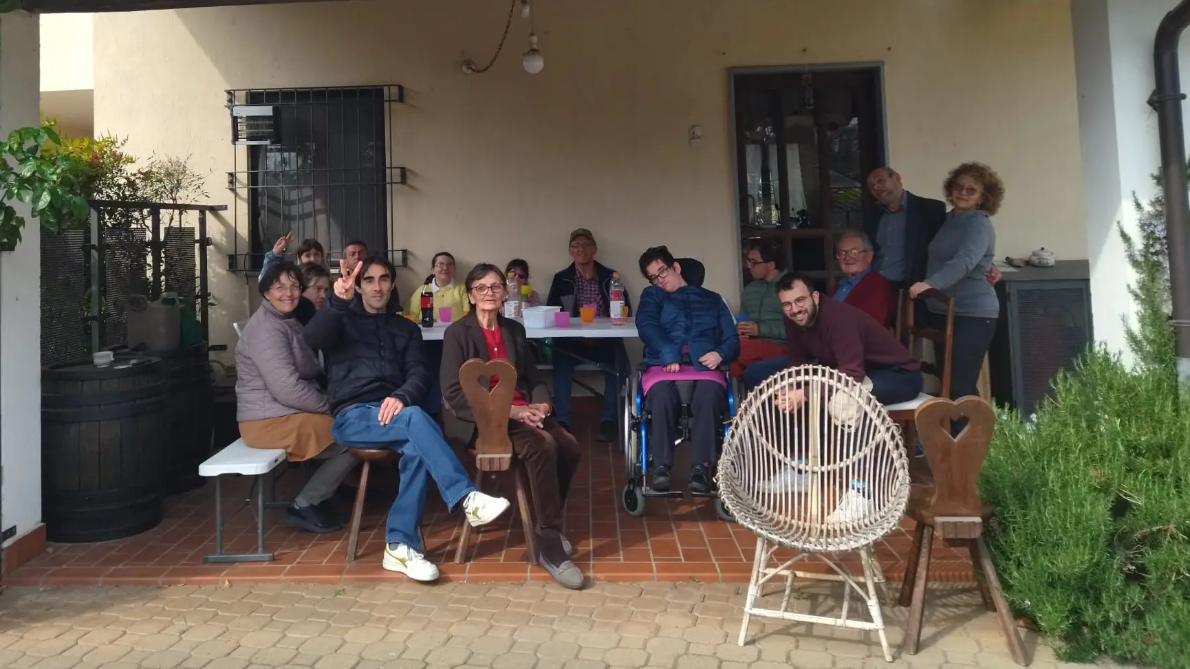 Gruppo di persone ad un tavolo da pranzo sotto a un portico